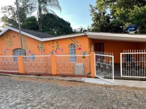 a small orange house with graffiti on it at Recanto Verde in Conceição dos Ouros