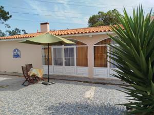 a house with a green umbrella in front of it at Cosy Loft by l'Arche de Jo in Santana