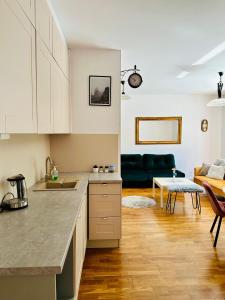 Una cocina con gabinetes blancos y una sala de estar. en Pohulanka Old City - parking & balcony, en Gdansk