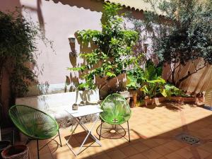 a patio with two chairs and a table and plants at Bellver bedrooms in Xàtiva +22 photos