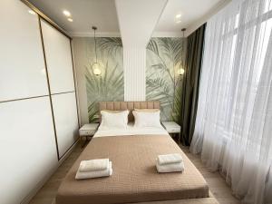 a bedroom with a bed with two towels on it at Citywide apartment BayTash Tower near GUM and TSUM in Bishkek