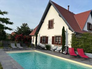 a house with a swimming pool in front of a house at Les Chambres Chez Christine in Ottrott
