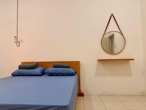 Kamuntingにある28 Harmoni Homestay, Kamuntingのベッドルーム1室(壁に鏡付きのベッド1台付)