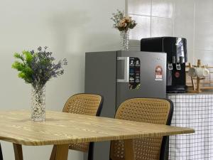Kamuntingにある28 Harmoni Homestay, Kamuntingのテーブル、椅子、冷蔵庫付きのキッチンが備わります。