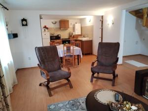 a living room with a table and chairs and a kitchen at Casa Catalyna in Predeluţ
