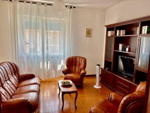 a living room with a couch and chairs and a tv at Livorno Life in Livorno