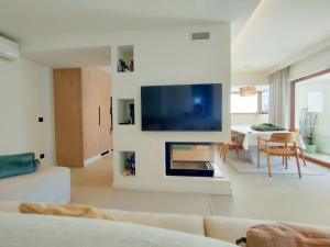 ein Wohnzimmer mit einem Sofa und einem Fernseher an der Wand in der Unterkunft Villa Esperança in Porches