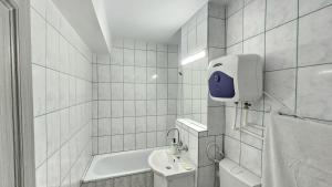 コンスタンツァにあるThe Anchor Apartmentの洗面台とバスタブのある白いバスルーム +16枚の写真