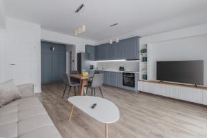 a living room with a couch and a table and a tv at Down to Earth at Waterview Collection in Oradea
