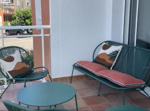 two chairs and a table on a balcony at Résidence la Pinède - appartement Flores in Le Barcarès