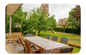 a wooden table and chairs in a yard at Hôtel Thiron Gardais in Thiron-Gardais +4 photos
