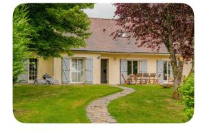 a house with a stone walkway in the yard at Hôtel Thiron Gardais in Thiron-Gardais