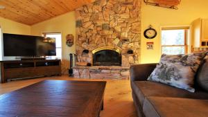 ein Wohnzimmer mit einem Sofa und einem Steinkamin in der Unterkunft Lakeside Oasis in Big Bear Lake