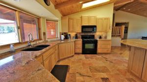 eine Küche mit Holzschränken und einem Herd mit Backofen in der Unterkunft Lakeside Oasis in Big Bear Lake