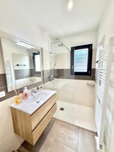a white bathroom with a sink and a shower at Studio Cosy - CLIM & Parking & WIFI in Aucamville