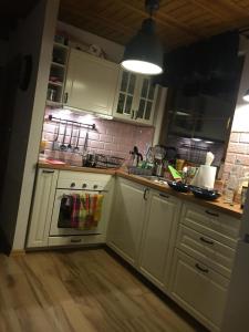 a kitchen with white cabinets and a stove top oven at Nowoczesny dom wakacyjny "Sole" nad jeziorem Gwiazdy, Ostoja Bukowo, Borowy Młyn, Kaszuby, region Gochy, z dala od miasta, dookoła lasy in Borowy Młyn +8 photos
