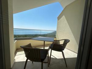 a balcony with a table and chairs and a view at Villa in a quiet area - Private Pool - Sport - Starlink - BBQ in Baška Voda
