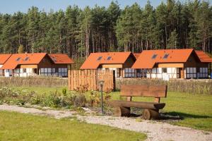 a park bench in front of a row of houses at Nowoczesny dom wakacyjny "Sole" nad jeziorem Gwiazdy, Ostoja Bukowo, Borowy Młyn, Kaszuby, region Gochy, z dala od miasta, dookoła lasy in Borowy Młyn
