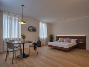 a bedroom with a bed and a table and a tableablish at Portica Homes Assisi in Assisi