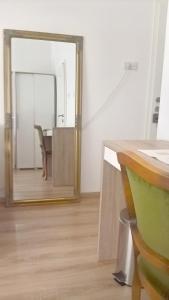 a mirror in a room with a table and a chair at San Eleuterio Guesthouse in Poreč