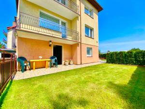 a house with a table and chairs in a yard at Podlesie in Ostrowo