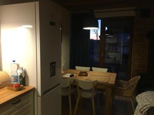 a kitchen with a table and chairs in a room at Nowoczesny dom wakacyjny "Sole" nad jeziorem Gwiazdy, Ostoja Bukowo, Borowy Młyn, Kaszuby, region Gochy, z dala od miasta, dookoła lasy in Borowy Młyn