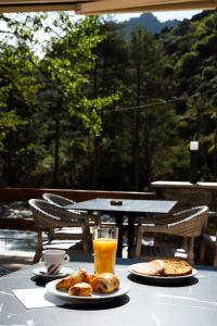 a table with plates of food and a glass of orange juice at Hotel Arena le Refuge in Corte +37 photos