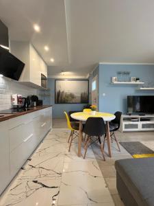 une cuisine et une salle à manger avec une table et des chaises dans l'établissement Apartament Katarzyna, à Międzywodzie