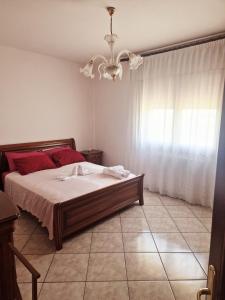 a bedroom with a bed with red pillows and a window at Ca' Elena in Codigoro