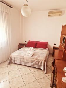 a bedroom with a bed with a red pillow at Ca' Elena in Codigoro