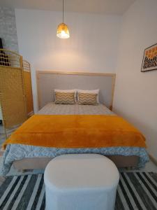 a bedroom with a large bed with a orange blanket at Cosy Loft Santana in Santana