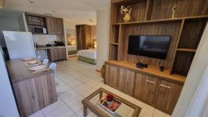 a living room with a flat screen tv and a kitchen at ApartHotel no Centro de Brasília in Brasilia