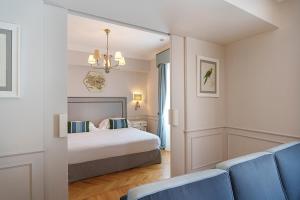 a hotel room with a bed and two blue chairs at Palazzo Manzi Terme & Spa in Casamicciola Terme +105 photos