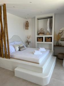 a white bedroom with a large white bed in it at Patela Luxury Suites in Panormos Kalymnos