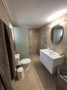 a bathroom with a toilet and a sink and a mirror at Olive House near the sea in Kharokopión