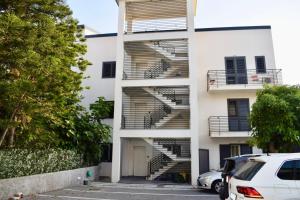 a white building with stairs on the side of it at Novea Apartments - Comodi Appartamenti con Parcheggio & Wi-Fi vicino Taormina in Taormina