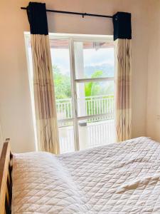 a bedroom with a bed and a large window at Heavenly Horizon Villa in Kandy