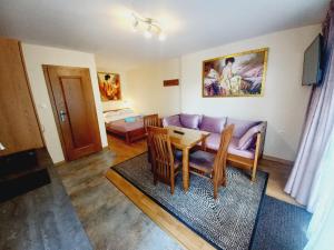 a living room with a couch and a table at APARTAMENTY i POKOJE "PASJA" - 2 minuty do plaży in Dźwirzyno
