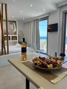 a table with a plate of food and wine glasses at Patela Luxury Suites in Panormos Kalymnos