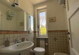 a bathroom with a sink and a toilet and a window at Agriturismo Tenuta La Muratella in Ponte Galeria +50 photos