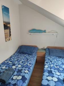 two beds in a room with a shelf on the wall at Pestka in Jastarnia