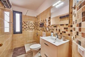 a bathroom with a toilet and a sink and a shower at Duplex Canela in Puerto Naos