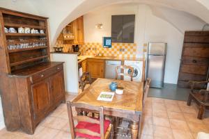 a kitchen with a wooden table and a refrigerator at Belle maison en pierre - Saint-Crépin - Guillestre - Queyras in Saint-Crépin