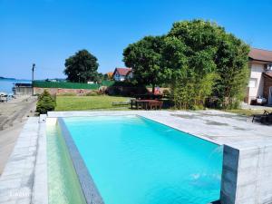 a large swimming pool in a backyard with a table and trees at Vila Maza in Smederevo