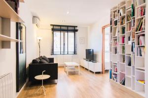 バルセロナにあるMorlan BCN Apartmentのリビングルーム(ソファ、テーブル、本棚付)