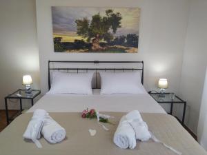 a bedroom with a bed with towels and flowers on it at Villa Makris in Zenempisátika