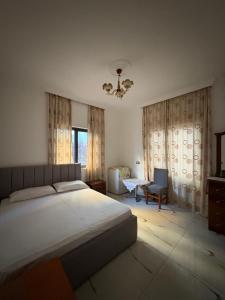 a bedroom with a large bed and a chair at Villa Klinton in Durrës