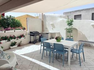 a patio with a white table and chairs and a piano at Villa Stefania in Magomadas +34 photos