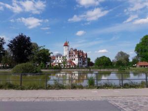 a large building in front of a body of water at Ferienhausidylle mit Motorboot und Kanu in Basedow