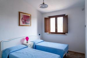 a room with two beds and a window at Villa Aratza in Orosei